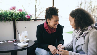 Two women talking at a cafe table