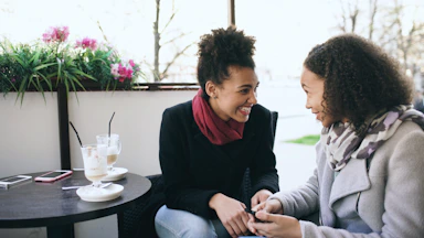 Two women talking at a cafe table