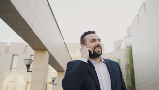 Man in suit talking on a cell phone outdoors.