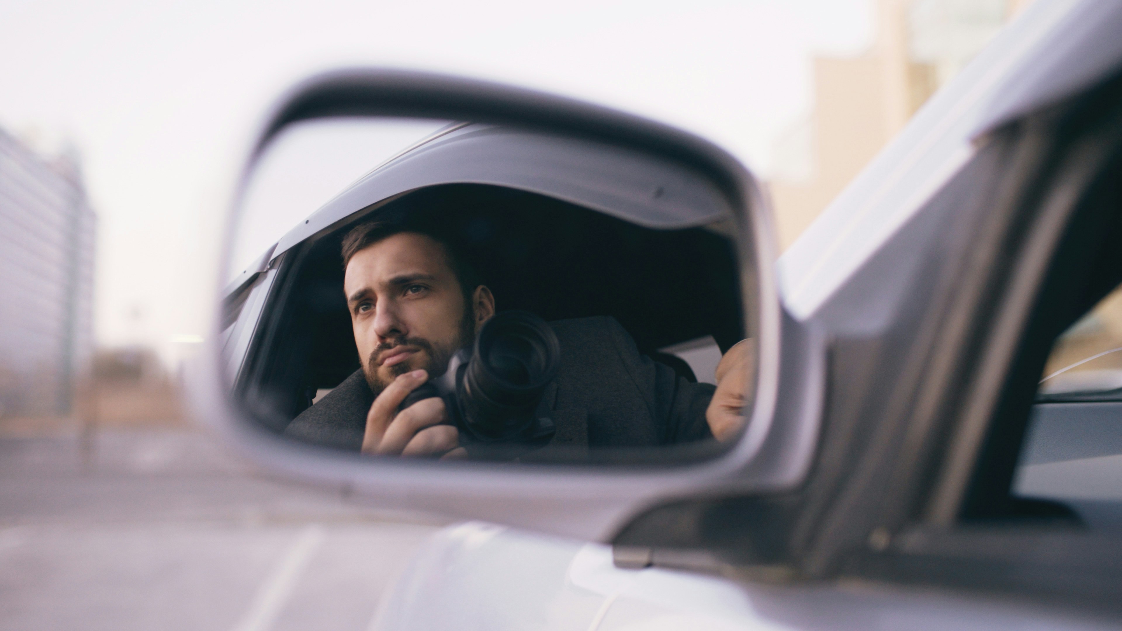 Man looking in car side mirror