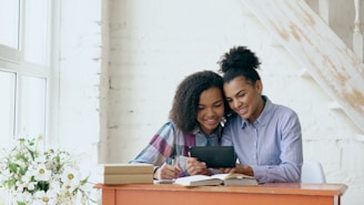 Two women reading a book together