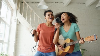 Two young women singing and playing guitar together