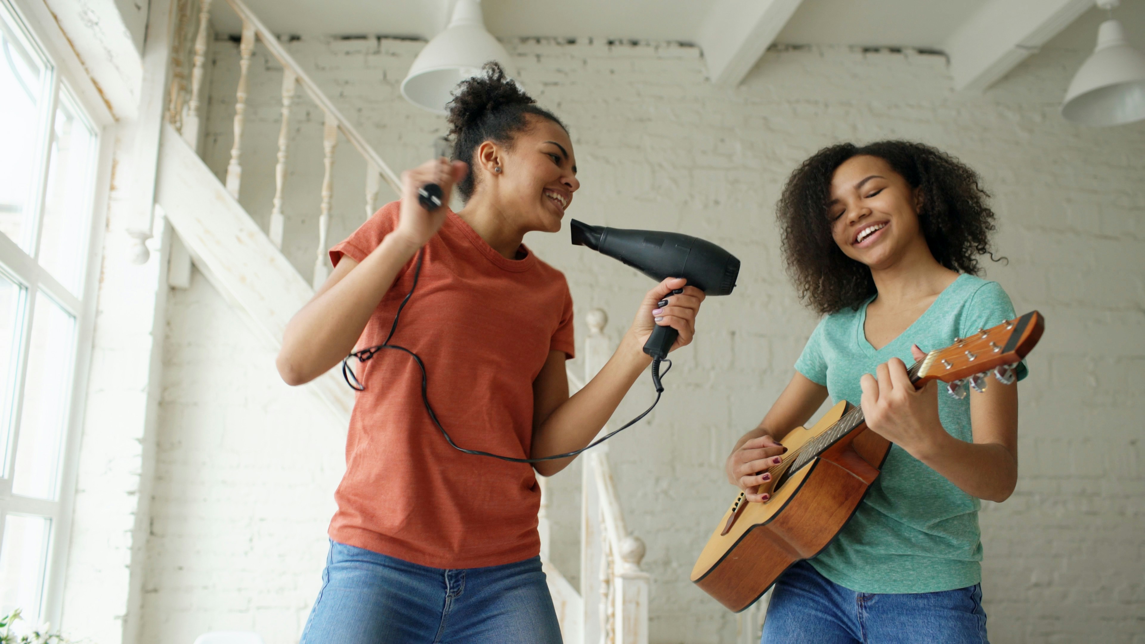 Two girls singing and playing guitar together
