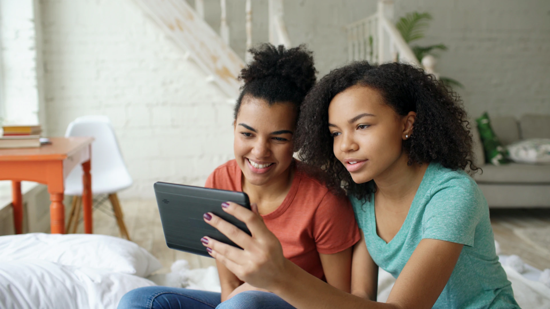 Two young women looking at a tablet together