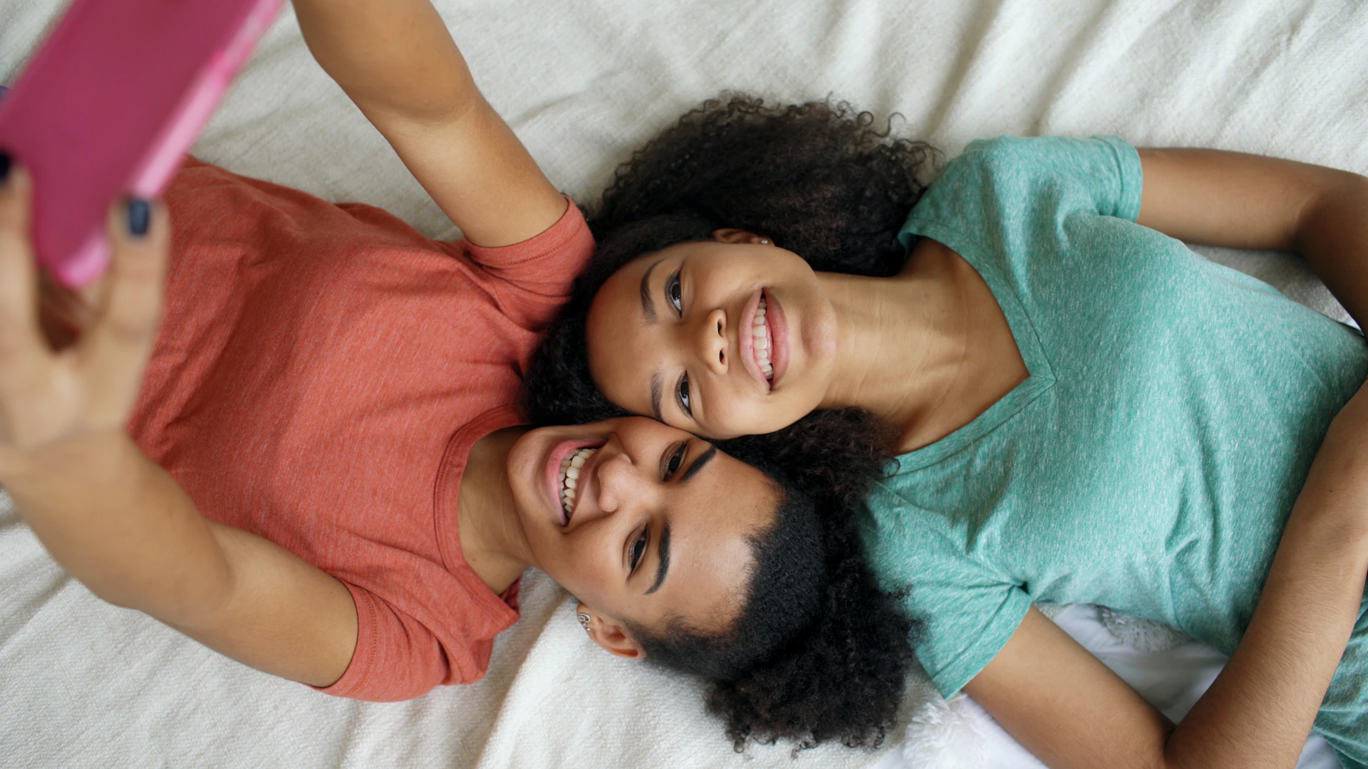 Two smiling friends taking a selfie together