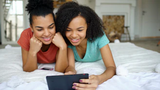 Two smiling young women looking at a tablet
