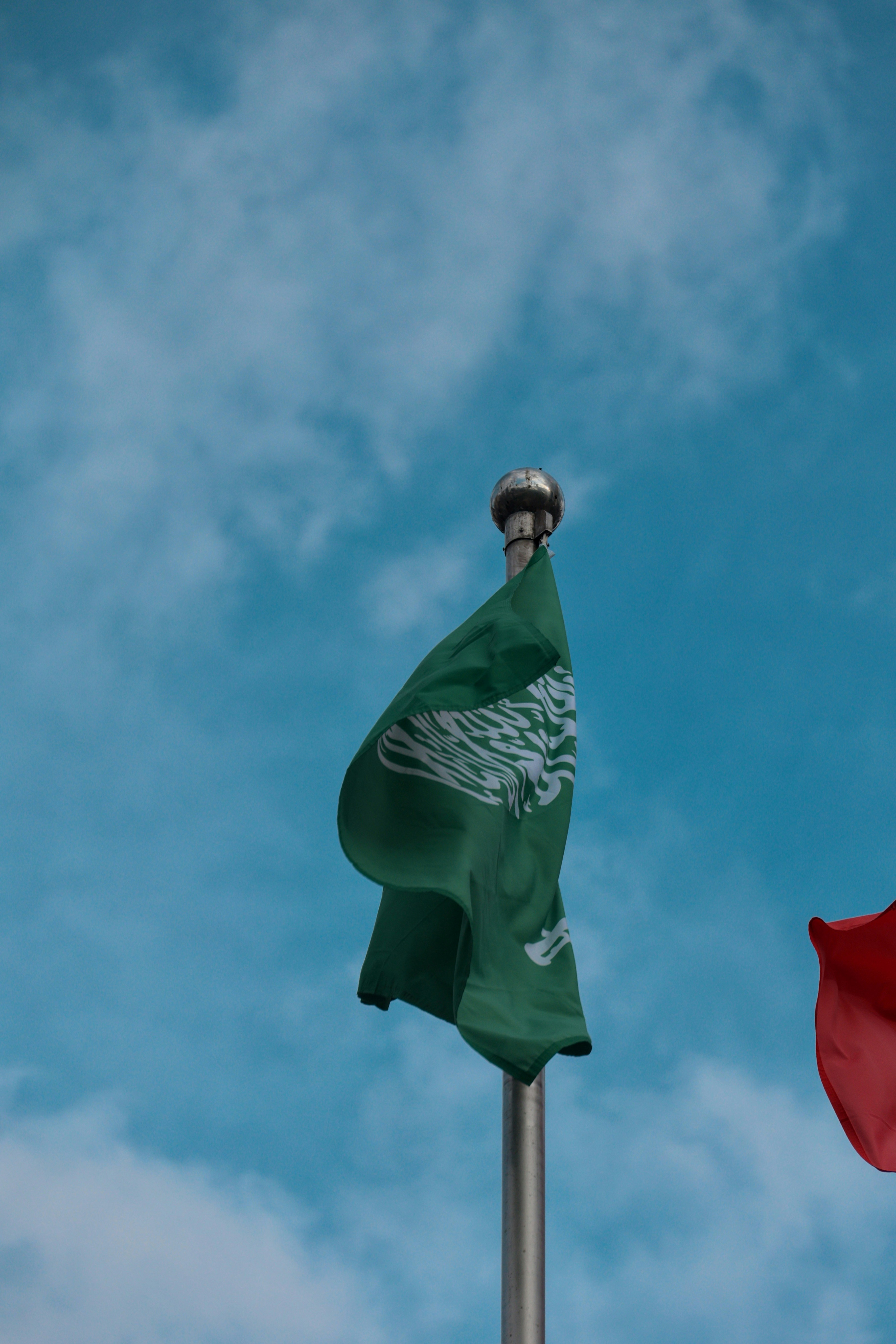 Green flag with white arabic script waving.