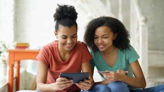 Two young women looking at a tablet device together