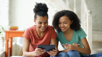 Two young women looking at a tablet device together