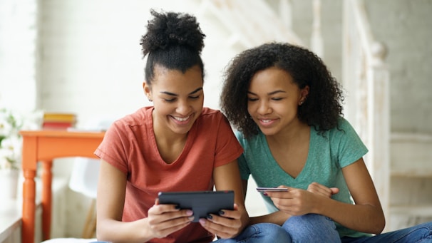 Two young women looking at a tablet device together