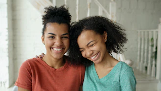 Mother and daughter smiling together indoors