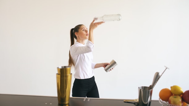 Bartender pouring liquid from bottle into shaker