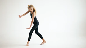 Young girl in black performing a dance move