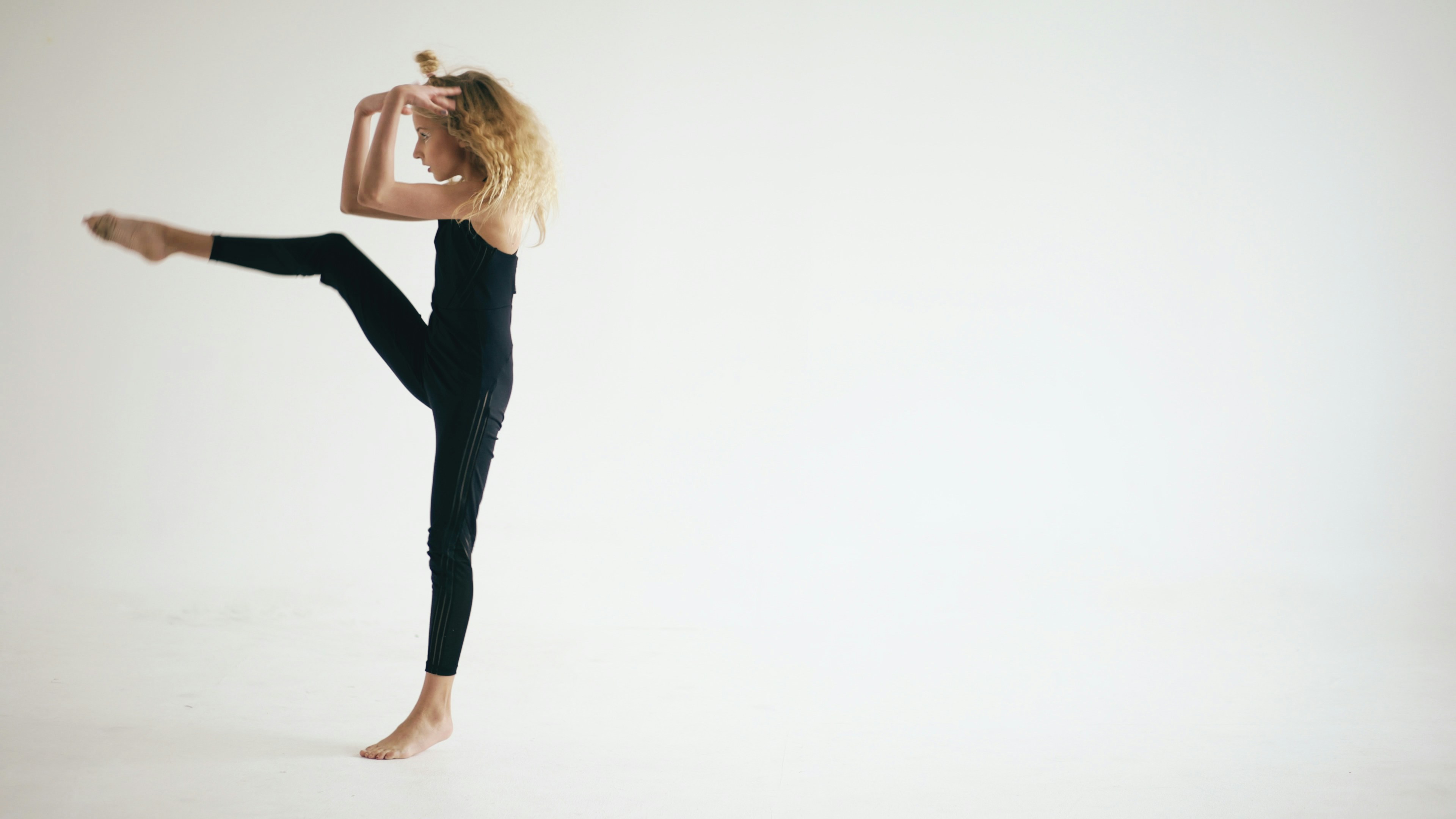 Young dancer in black leotard striking a graceful pose