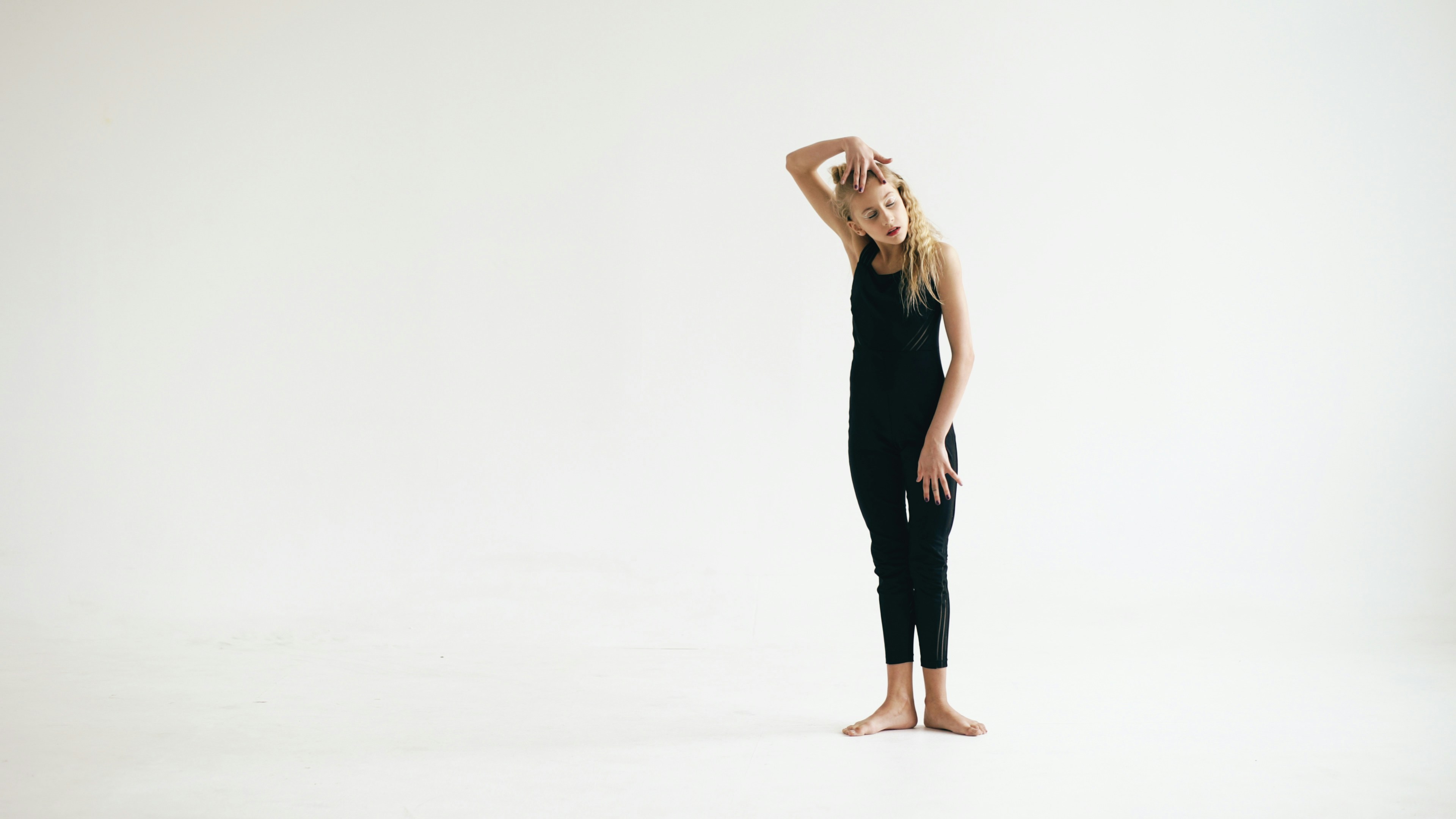 Young girl in black leotard on white background