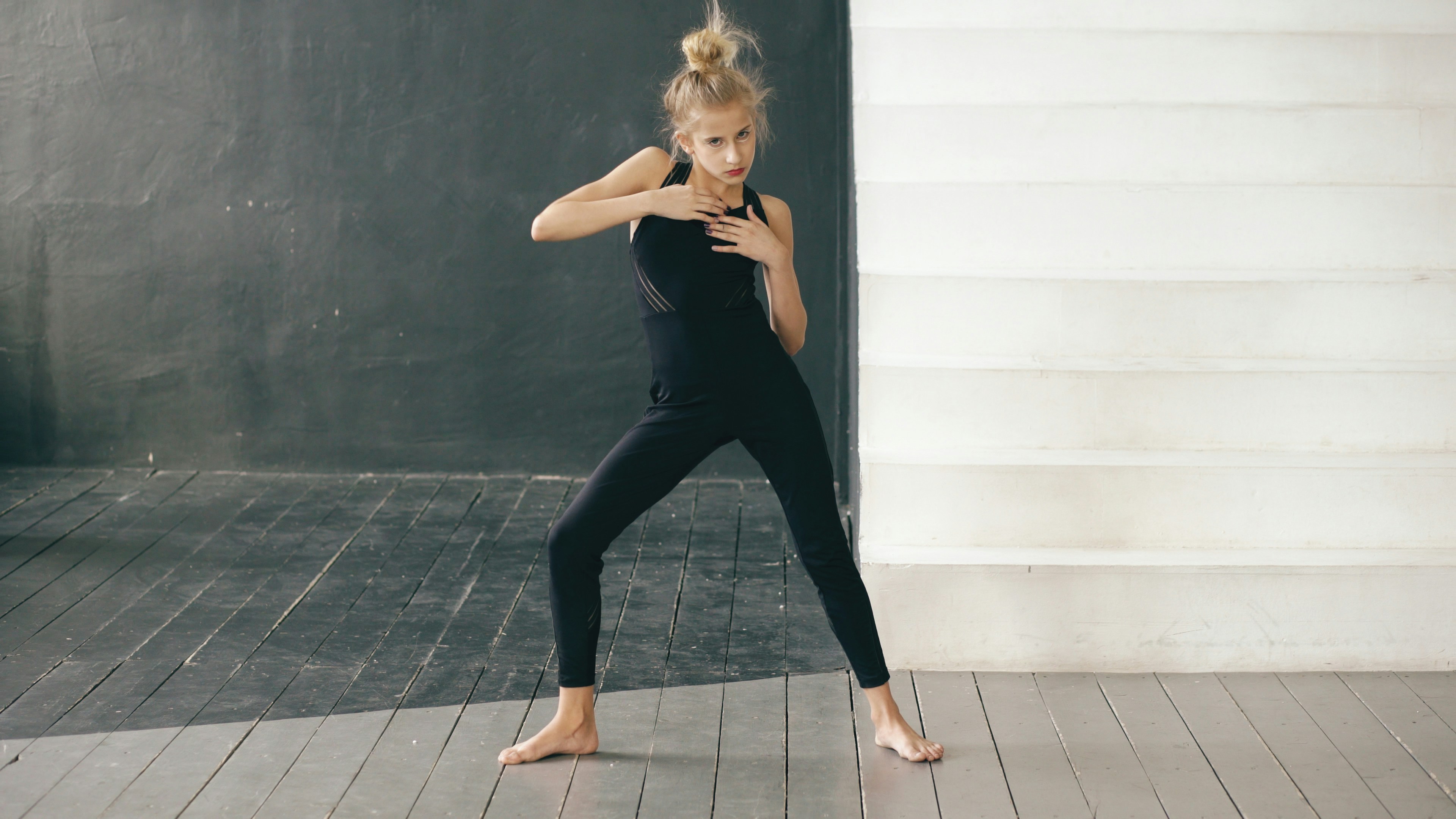 Young dancer in black performing in studio.