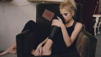 Young woman in black clothing sitting in armchair