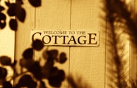 Welcome to the cottage sign on wooden door.