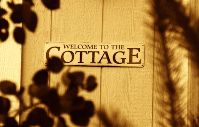 Welcome to the cottage sign on wooden door.