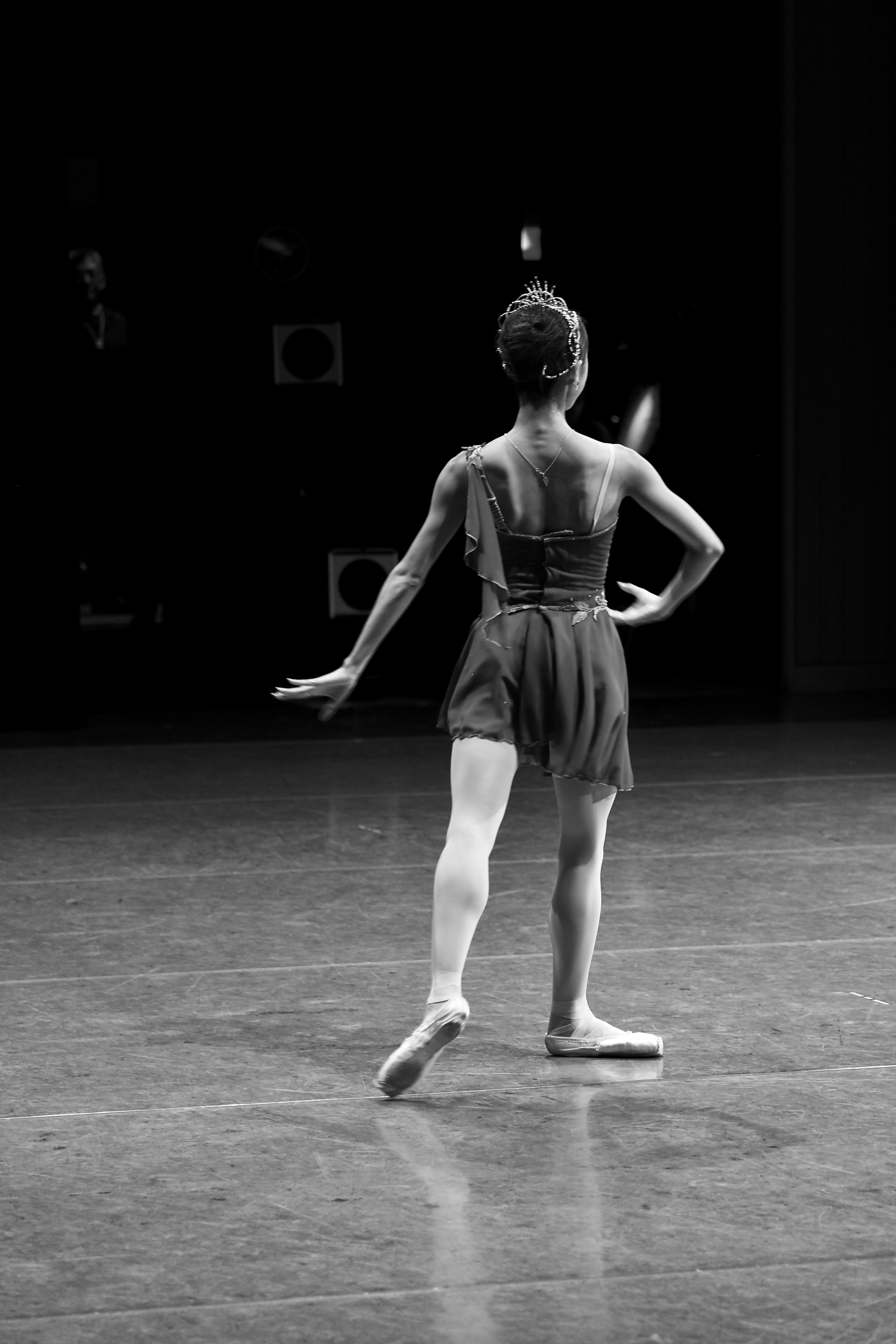 Ballerina performing on a dark stage with a spotlight