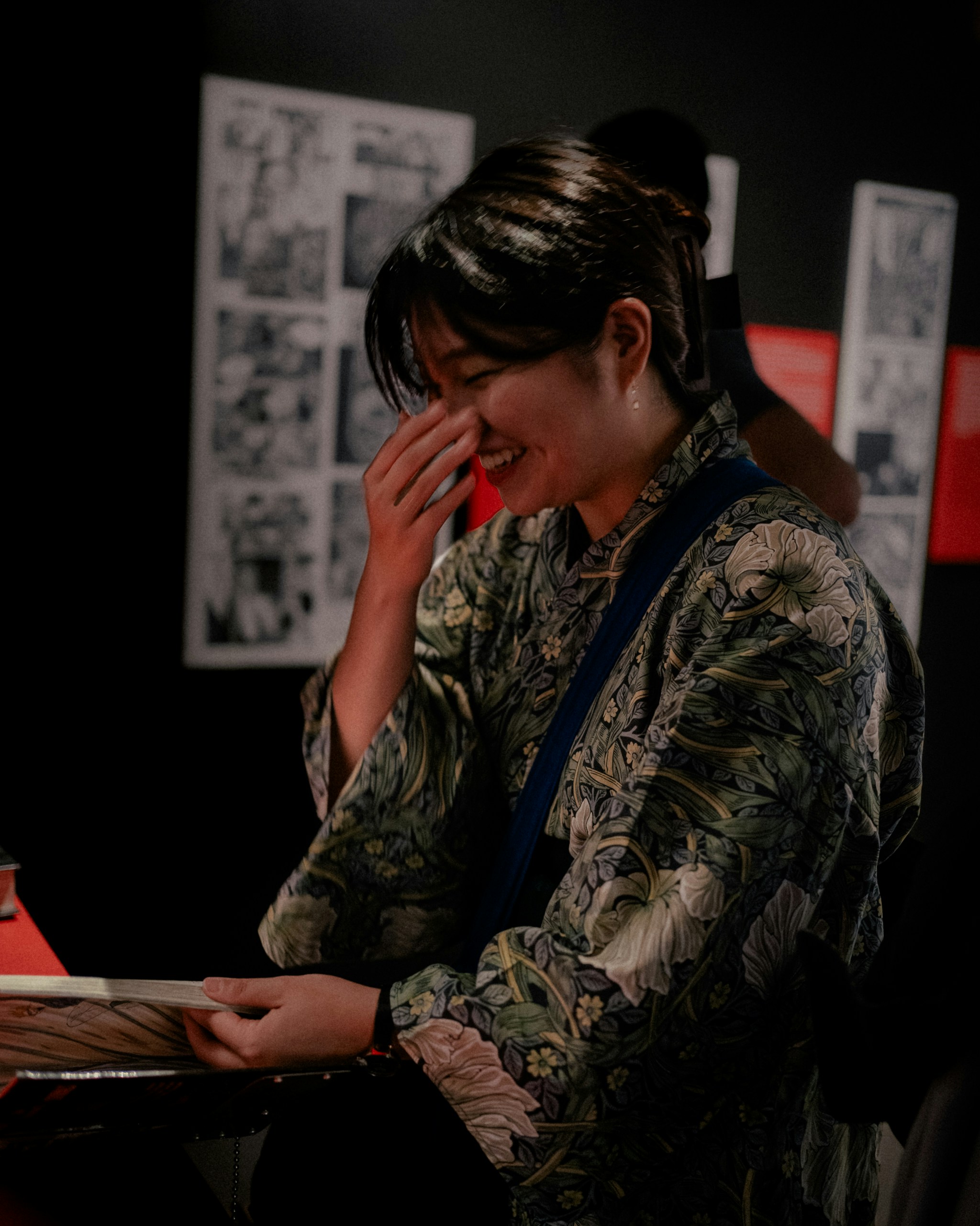 Woman in a patterned kimono laughing with her hand on her face
