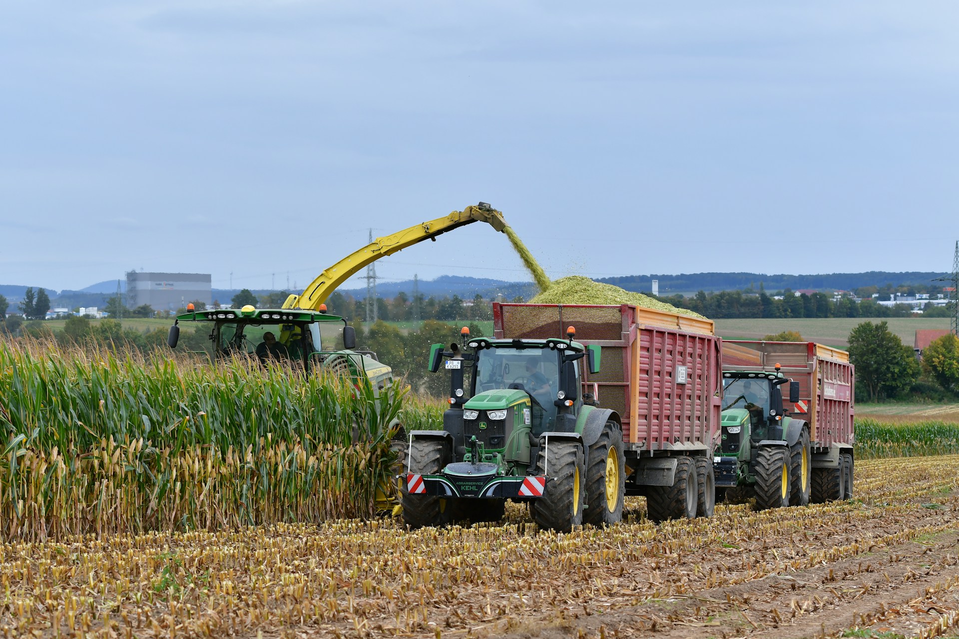 Tractors harvesting corn in a field