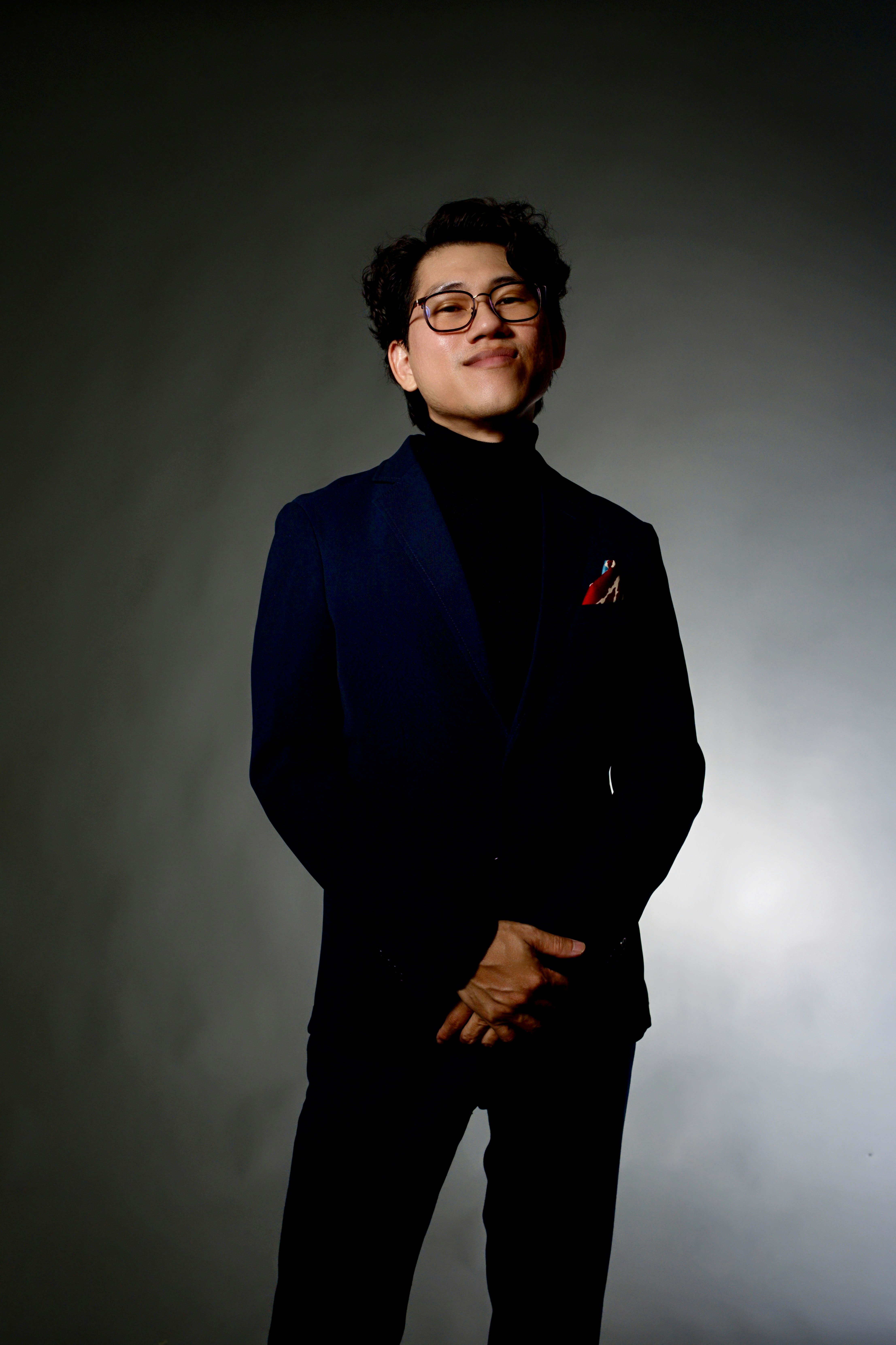 Man in suit and turtleneck smiling