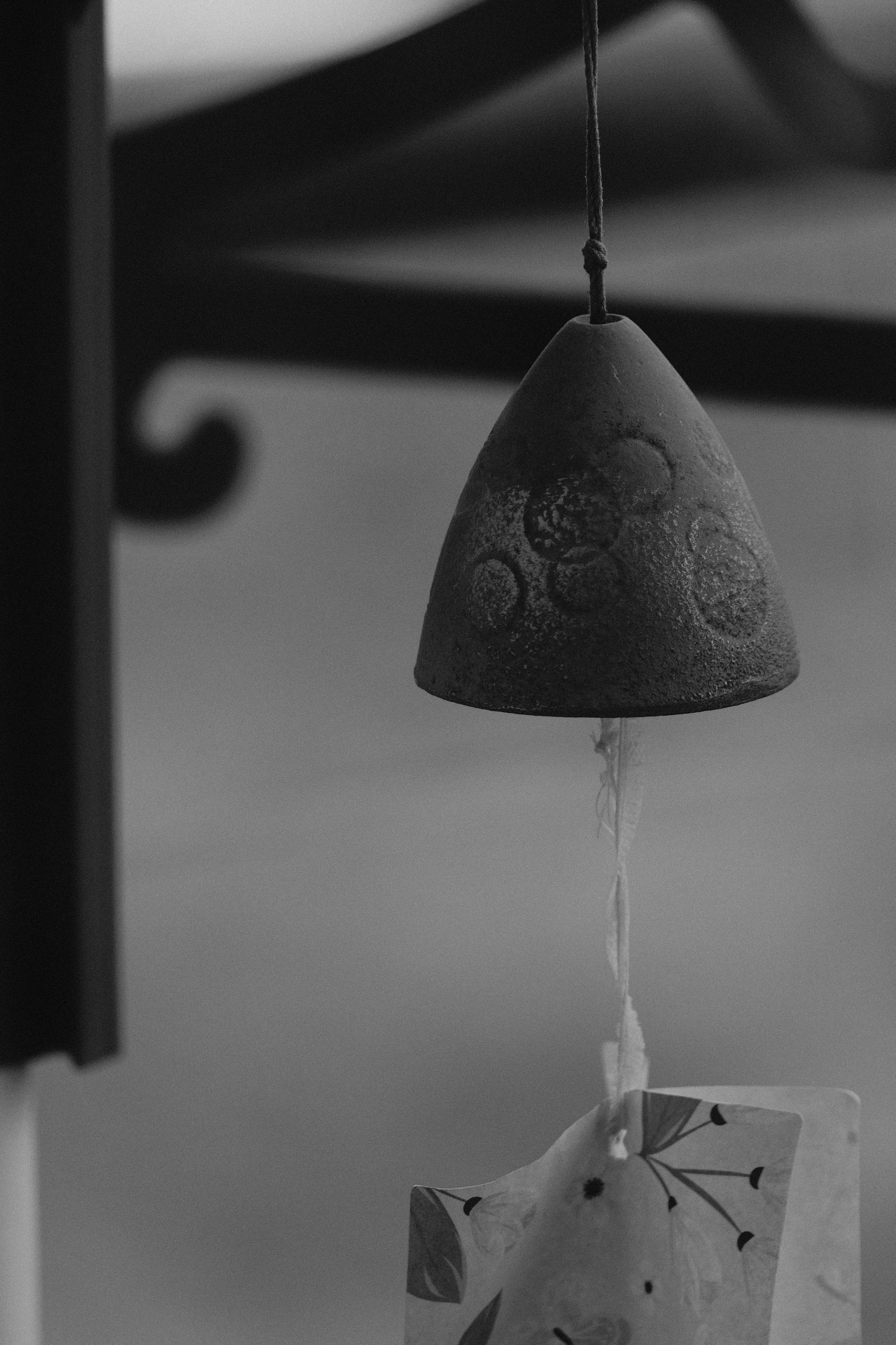 A ceramic wind chime hangs outdoors.