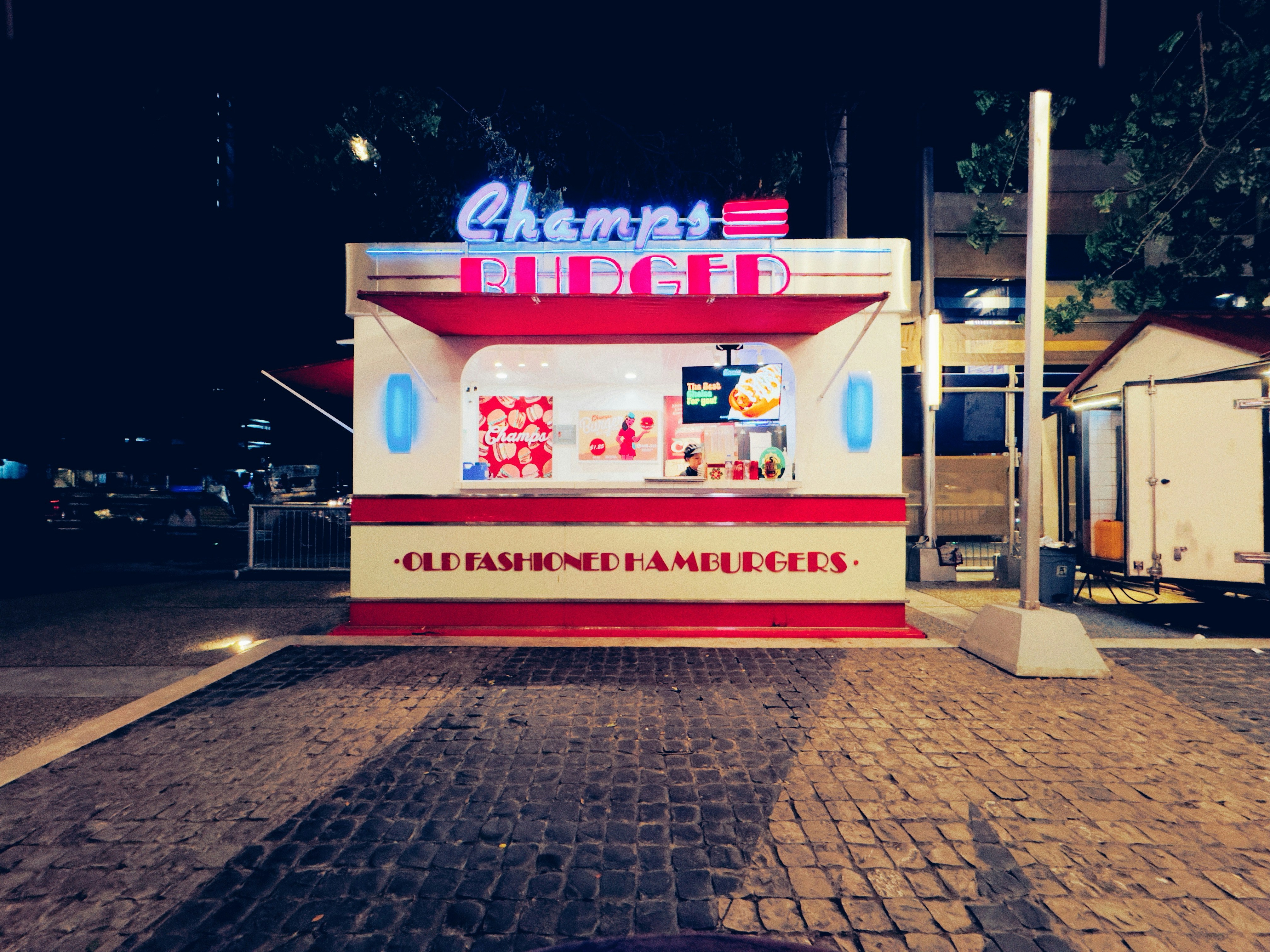 Retro food stand at night with neon lights.