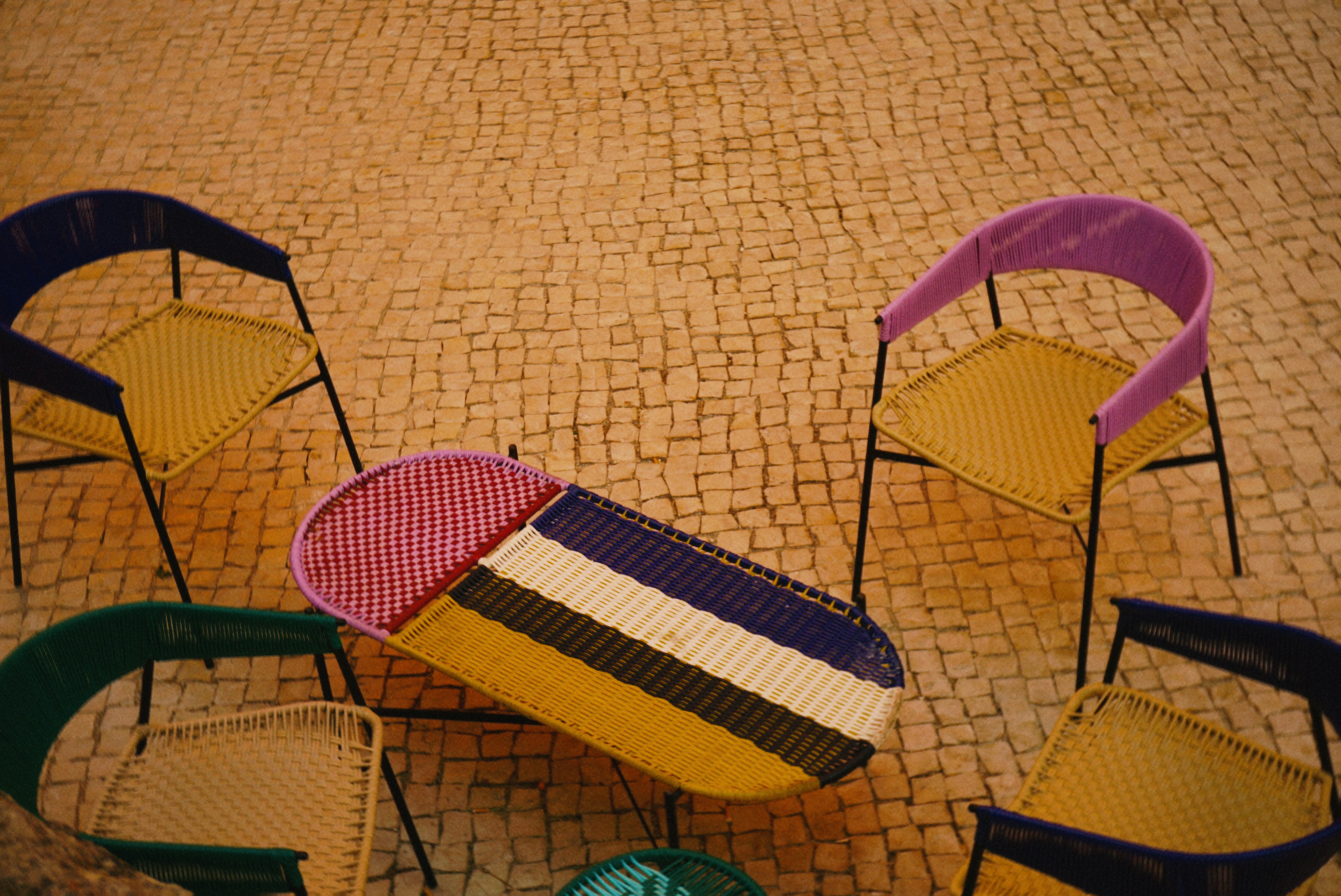 Colorful woven chairs surround a large eraser object