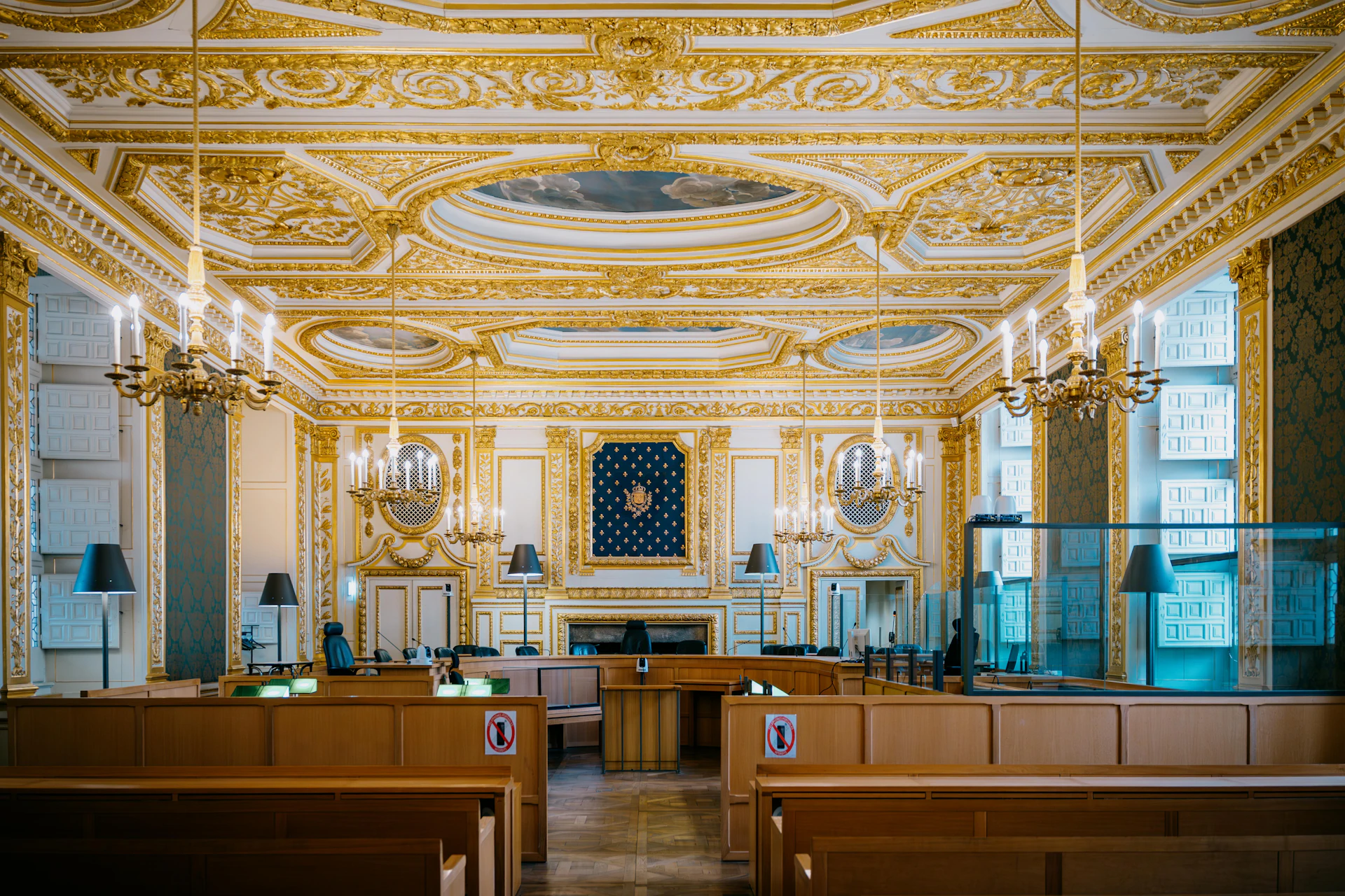 Ornate courtroom with gilded decorations and chandeliers