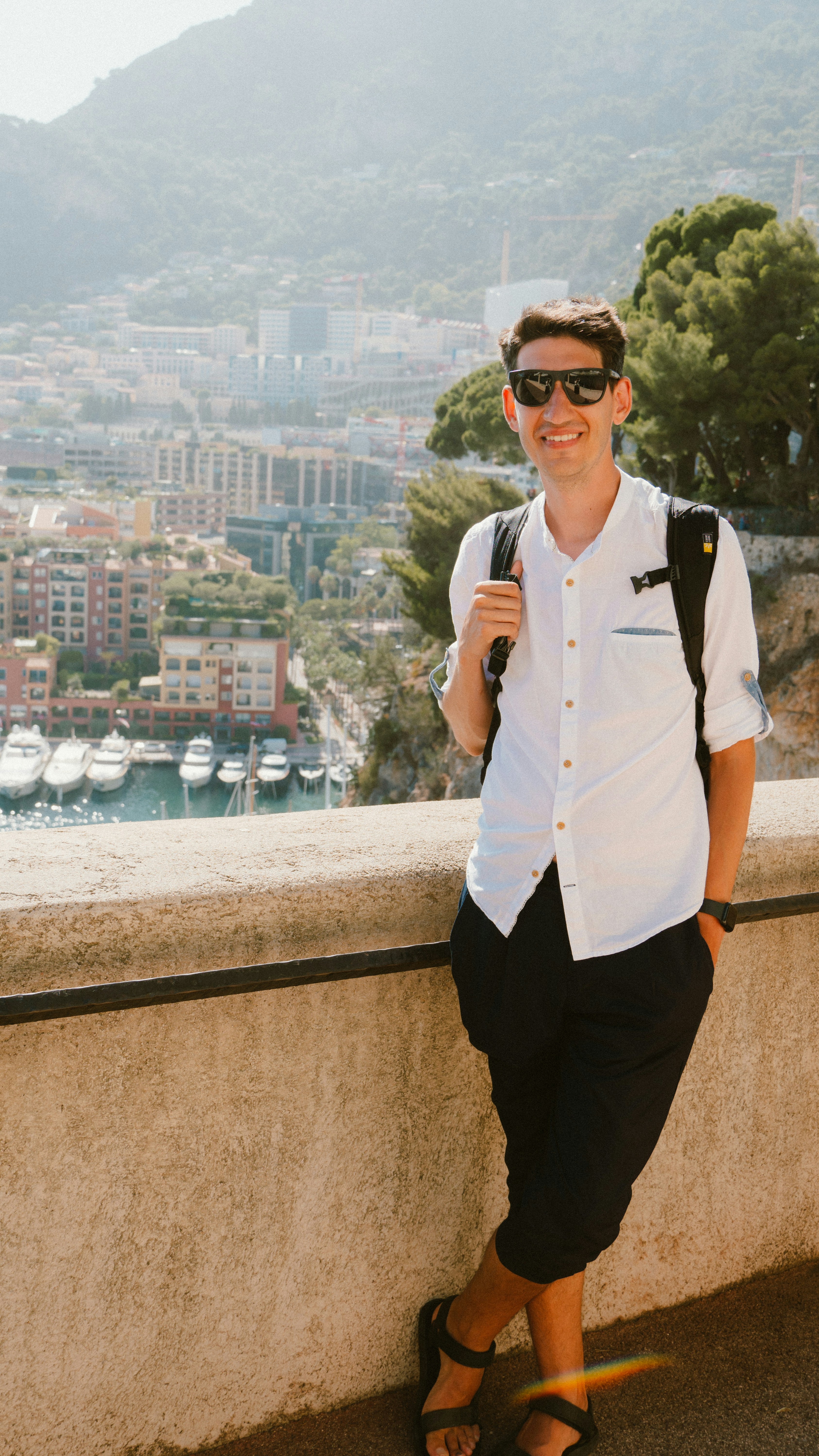 Smiling man in sunglasses with city and harbor view