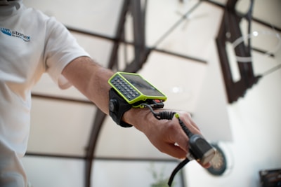 Man wearing a device on his arm with a cable.