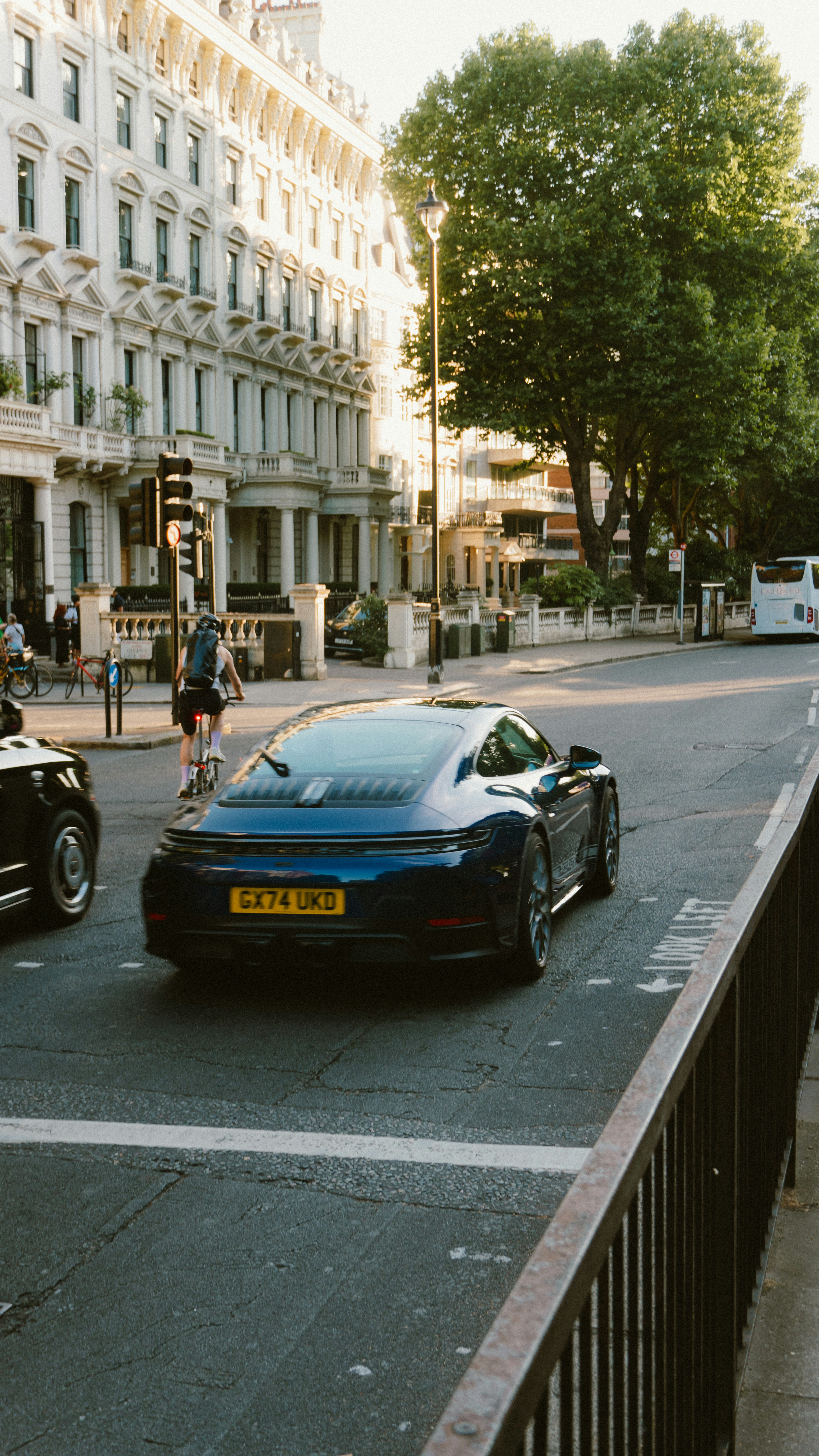 Blue porsche driving down a city street.
