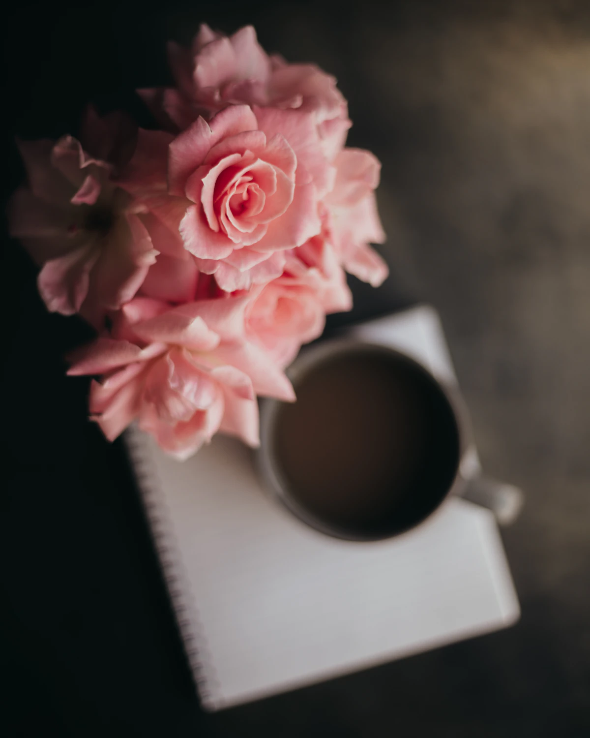 Rosen, Notizbuch und Kaffee als Symbol für eine kleine bewusste Belohnung