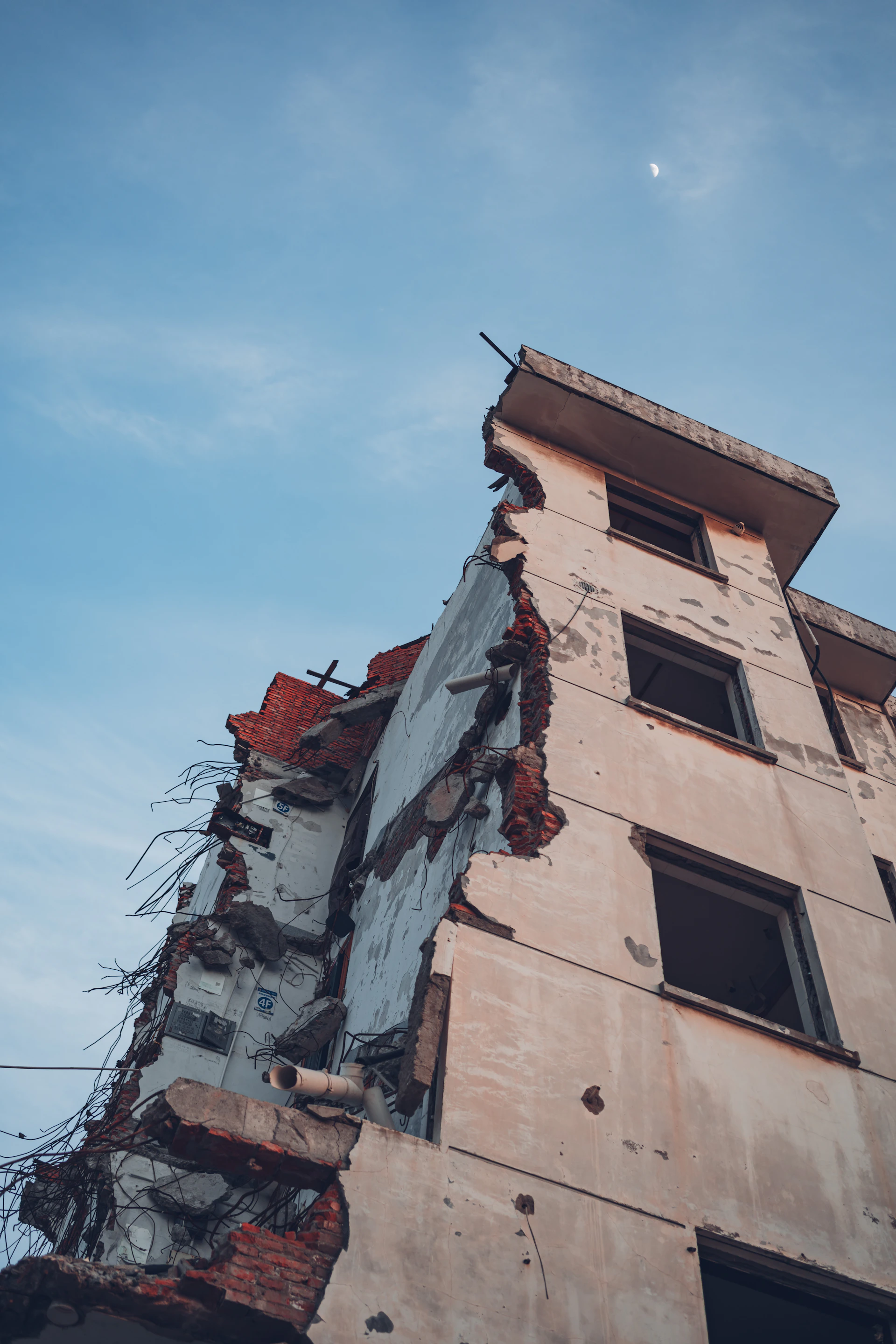 Partially demolished building against a blue sky
