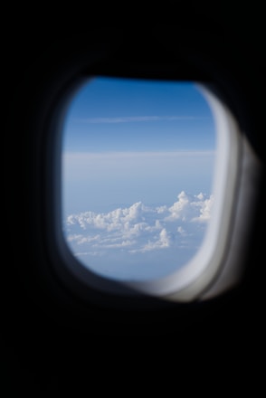 View of clouds and blue sky from airplane window