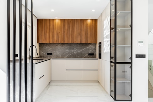 Modern white and wood kitchen with marble backsplash.