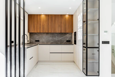 Modern white and wood kitchen with marble backsplash.