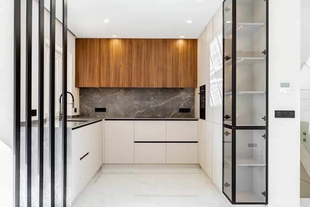 Modern white and wood kitchen with marble backsplash.