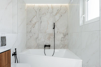 Modern bathroom with white marble and bathtub.