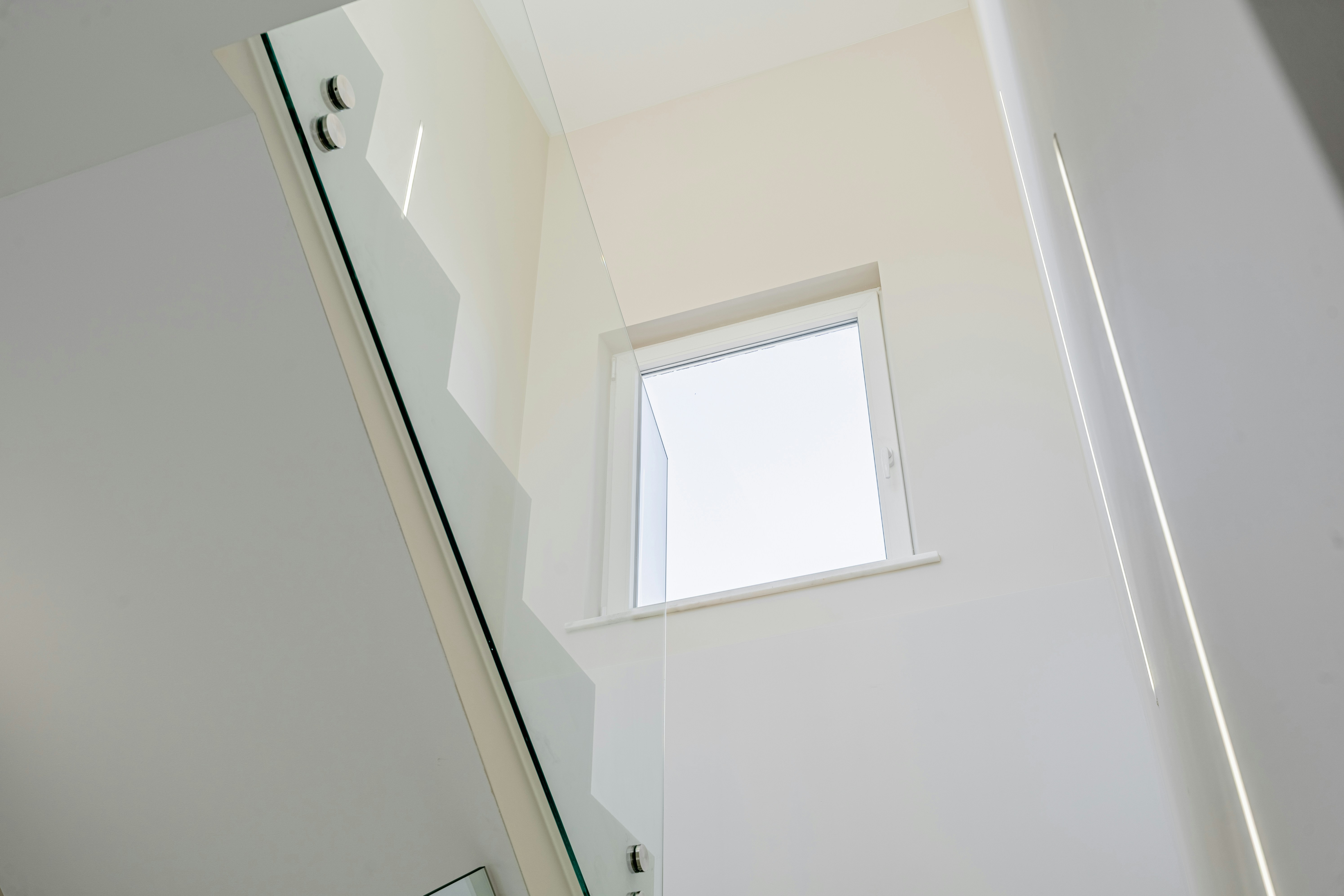 Modern staircase with glass railing and marble steps