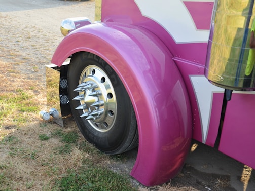 Close-up of a pink truck fender and wheel.