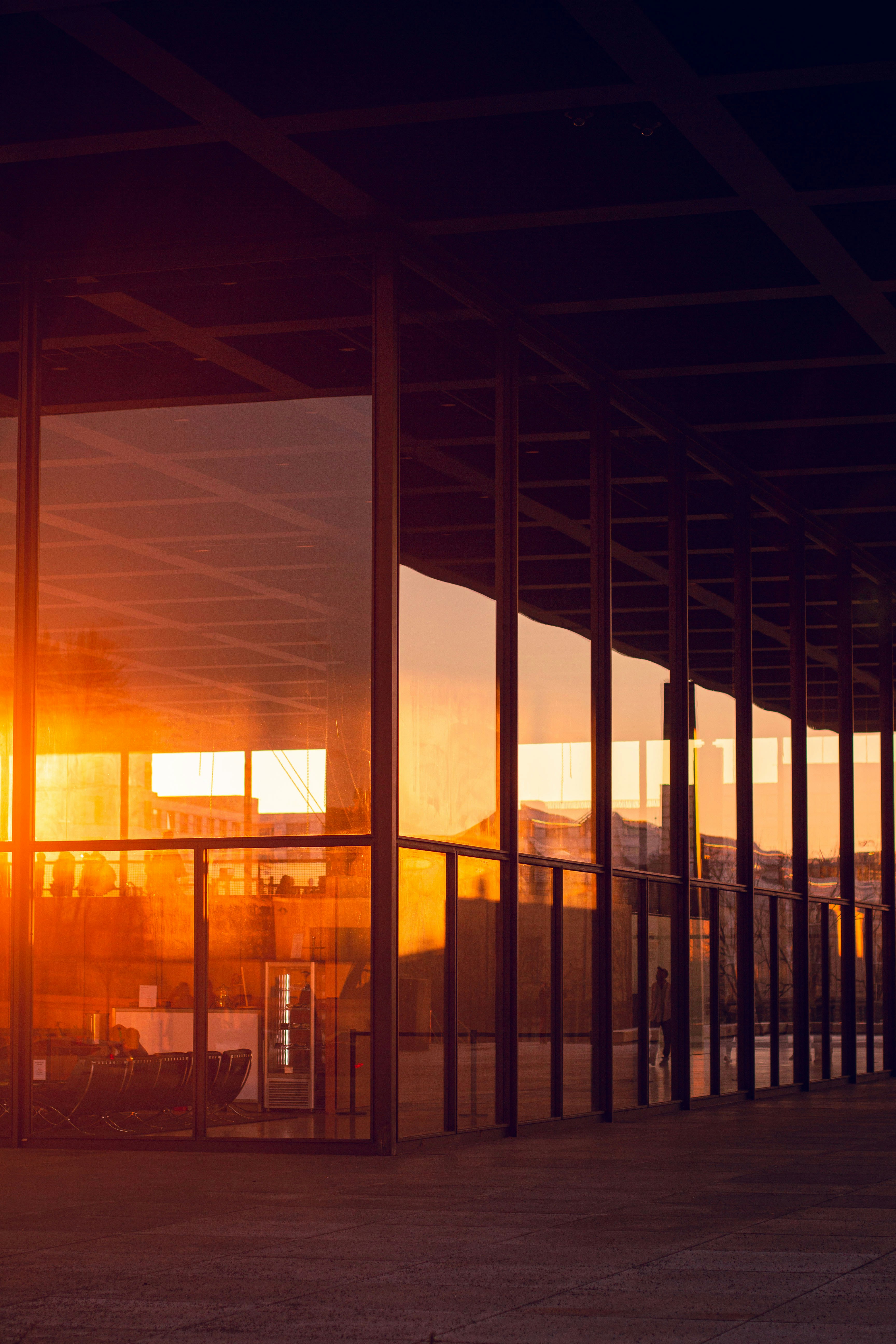 Sunset reflects on a modern building's glass facade.