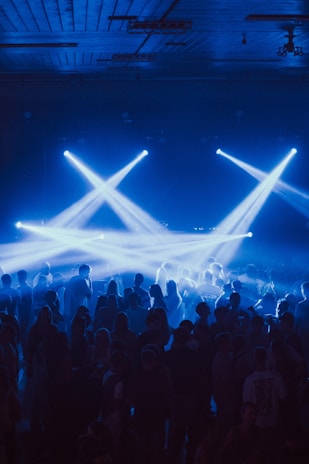 Crowd enjoying a concert with blue stage lights.