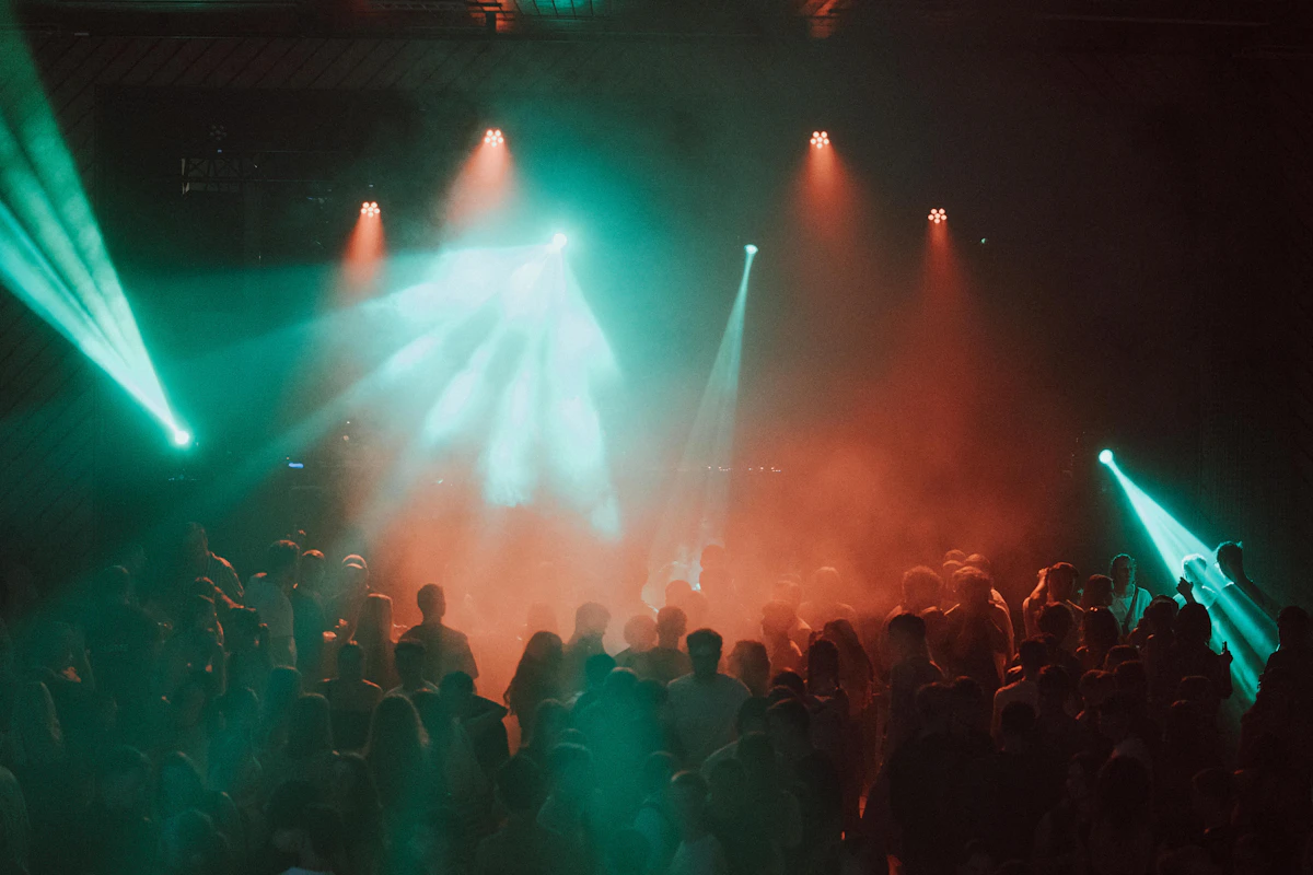Club-goers dancing under colorful stage lights