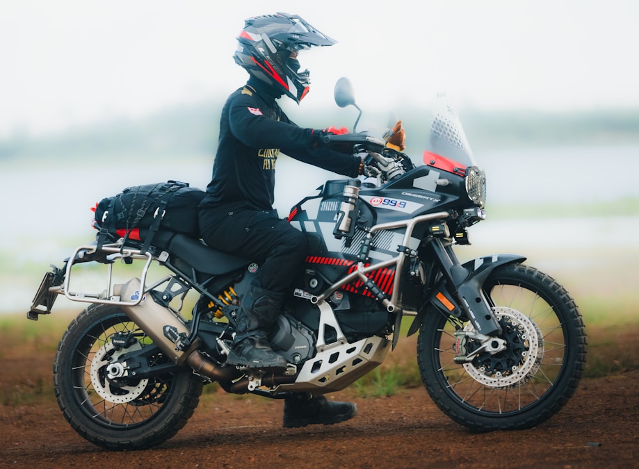 Adventure rider on a dual-sport motorcycle wearing tall technical riding boots