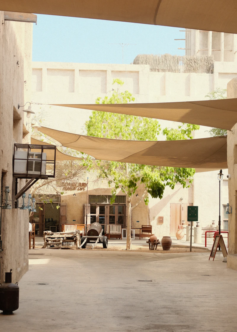 Courtyard with shade sails over traditional architecture