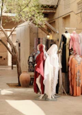 Mannequins display traditional clothing outside a shop.