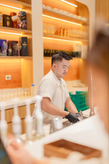 Bartender washing dishes behind a bar counter